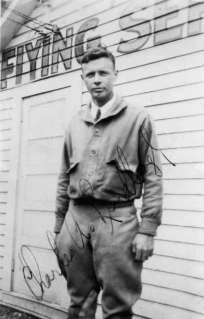 Autographed photo of Charles Lindbergh in flying gear standing outside a typical 'shack' at an airfield. Very likely at the old Bowles Airport in Agawam, Massachusetts, just across the Connecticut Ri