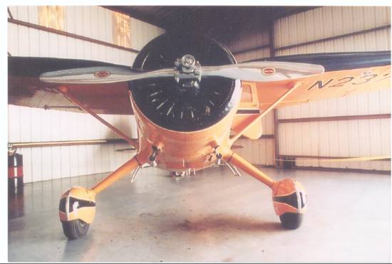 A Stinson Reliant that has had a nose-over mishap is shown righted in an Ottumwa Iowa hangar.