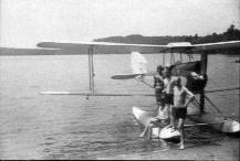 Vacationers at Camp Limberlost near Petersburg Ontario, about 1929, stand on pontoon of a DeHaviland Gypsy Moth biplane. 