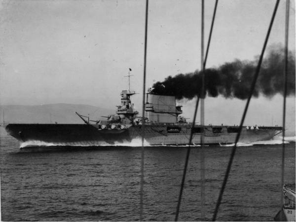 This is USS Lexington CV-2 or USS Saratoga CV-3. Both were built as battle cruisers and then had to be converted to carriers by one of the naval treaties after WW I.  Shown here with her original 8 i